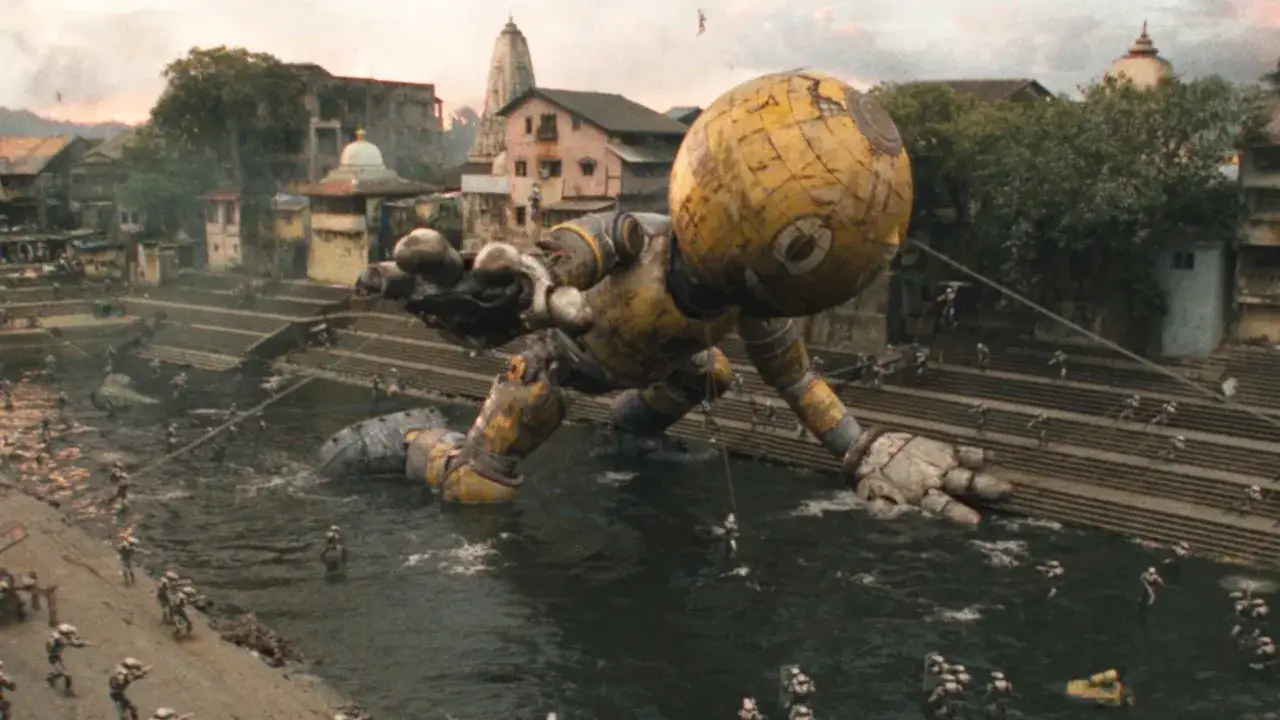 Gigantesco robot giallo in un fiume, circondato da piccole figure umane. Sembra in uno stato elettrico di caos.