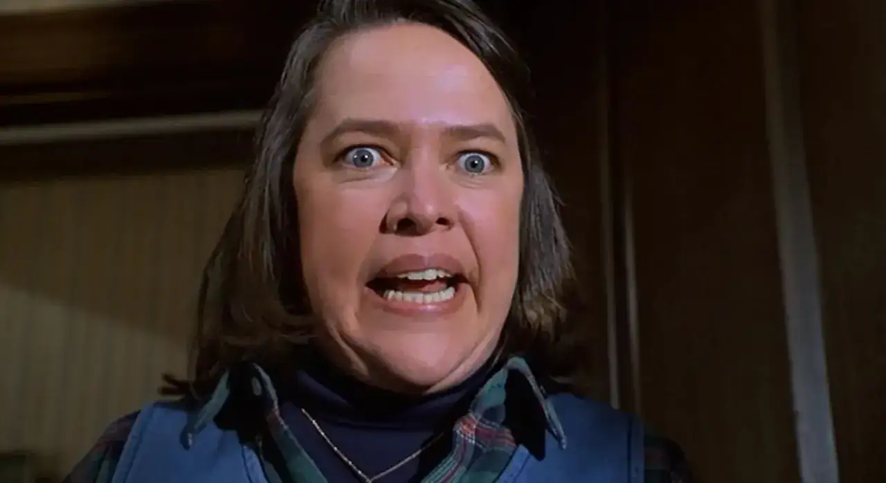 Kathy Bates con occhi sbarrati e bocca aperta in una scena di un film. La sua espressione suggerisce terrore o sorpresa.