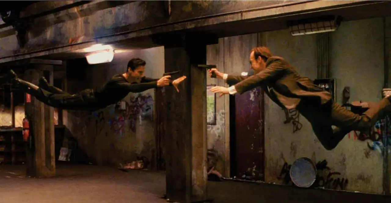Il cast di Matrix in un duello aereo, sfidando la gravit&agrave; con pistole in pugno.