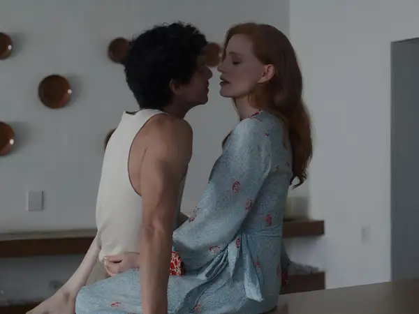 Jessica Chastain in un film, vicina a un uomo con capelli ricci. Lei indossa un vestito azzurro con motivi rossi.