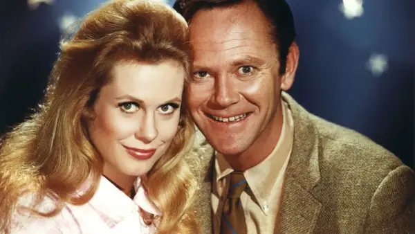 Il cast di Vita da strega: Elizabeth Montgomery e Dick York sorridono vicini, con lei che indossa una camicetta rosa e lui una giacca di tweed.