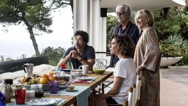 Una famiglia riunita per una colazione all'aperto, tra risate e sguardi pensierosi. Un momento di gioia e riflessione, una vera croce e delizia.