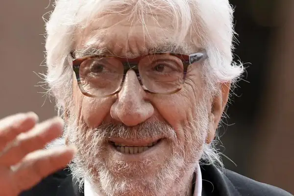 Ritratto di Gigi Proietti, con barba e capelli bianchi, occhiali da vista. La sua morte ha lasciato un vuoto nel cuore di molti.