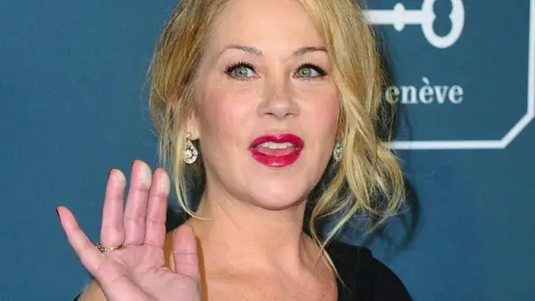 Christina Applegate, icona di film e programmi TV, saluta con un sorriso smagliante e labbra rosse.