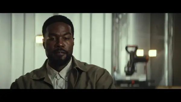 Primo piano di un uomo con barba, in abiti casual, in una scena della serie TV "Man on Fire".
