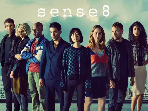 Il cast di Sense8, otto persone diverse ma connesse, posano insieme sotto un cielo nuvoloso.