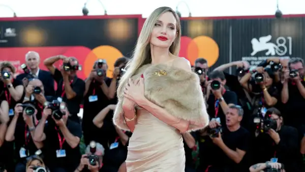 Angelina Jolie a Venezia, splendida sul red carpet, circondata da flash e fotografi.